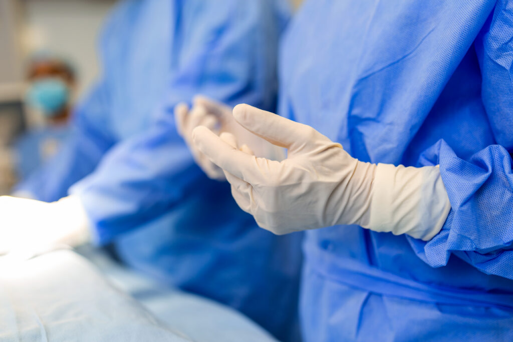 Portrait of beautiful female doctor surgeon putting on medical gloves standing in operation room. Surgeon at modern operating room - Dr.成井の毛髪LAB – AGA対策から植毛最新技術まで